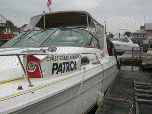 Photos of an Auxiliary Boat, life jacket and Coast Guard Auxiliary Logos